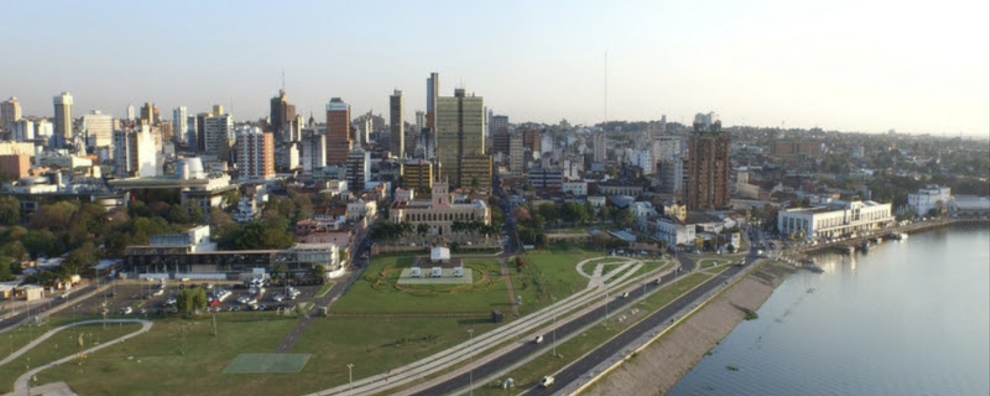 Vista del skyline de Asunción al atardecer desde la Costanera, con el río Paraguay en primer plano